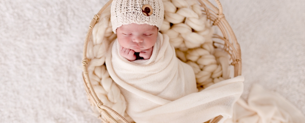 newborn baby in soft neutral wrap